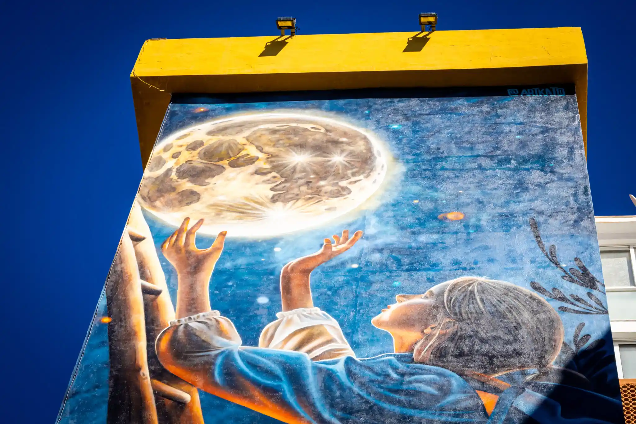 Imagen de un mural en un edificio con palmeras pintadas